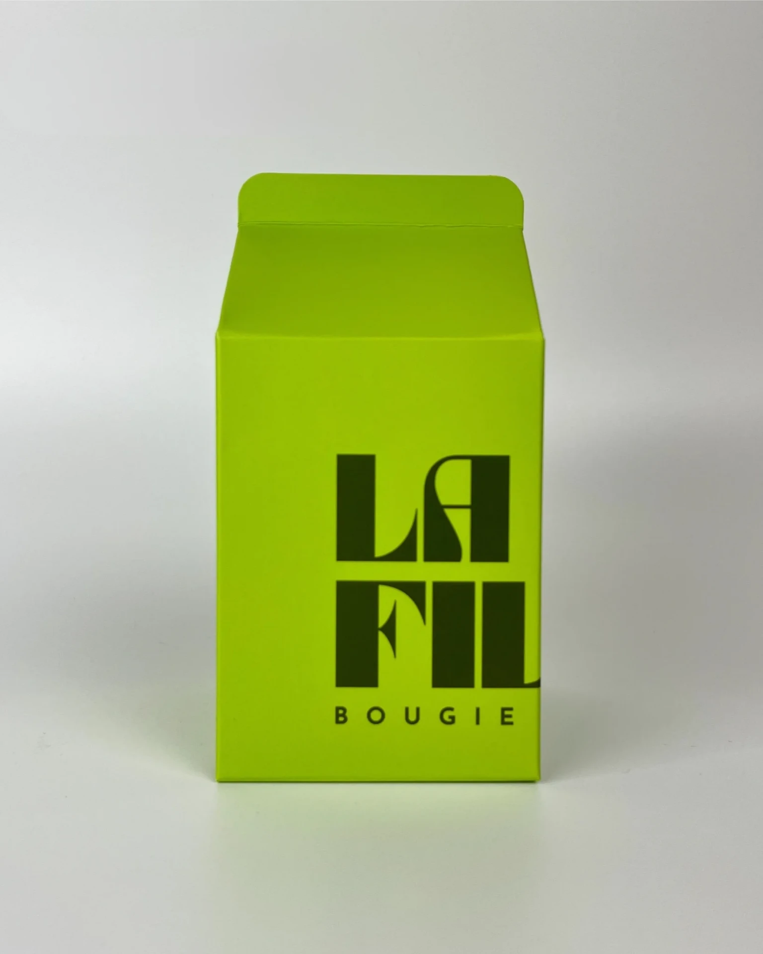 Front view of the apple green and dark green La Fille Milk Box packaging for the COCO & CITRUS scented candle.