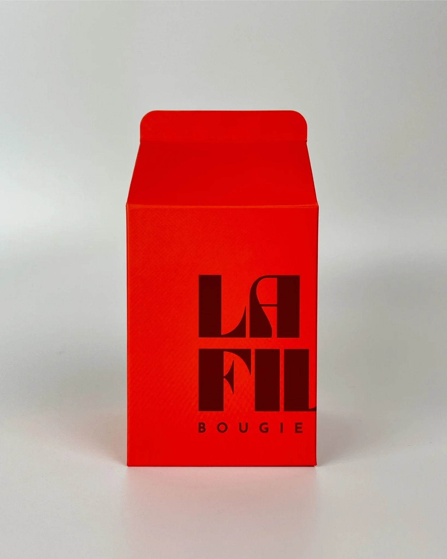 Front view of the red and burgundy La Fille Milk Box packaging for the ANDALUSIAN JASMINE scented candle.