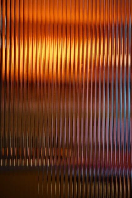 Lumière ambrée diffusée à travers un verre strié.