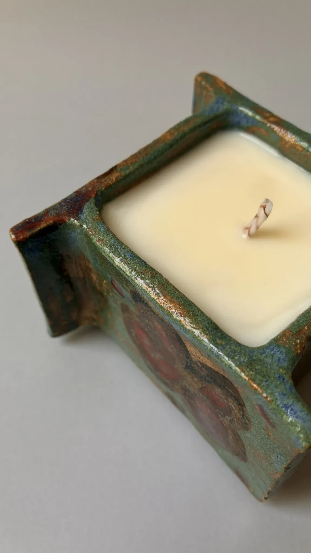 Détail de la cire de soja, de la mèche en coton et du contenant en grès émaillé fait main.
