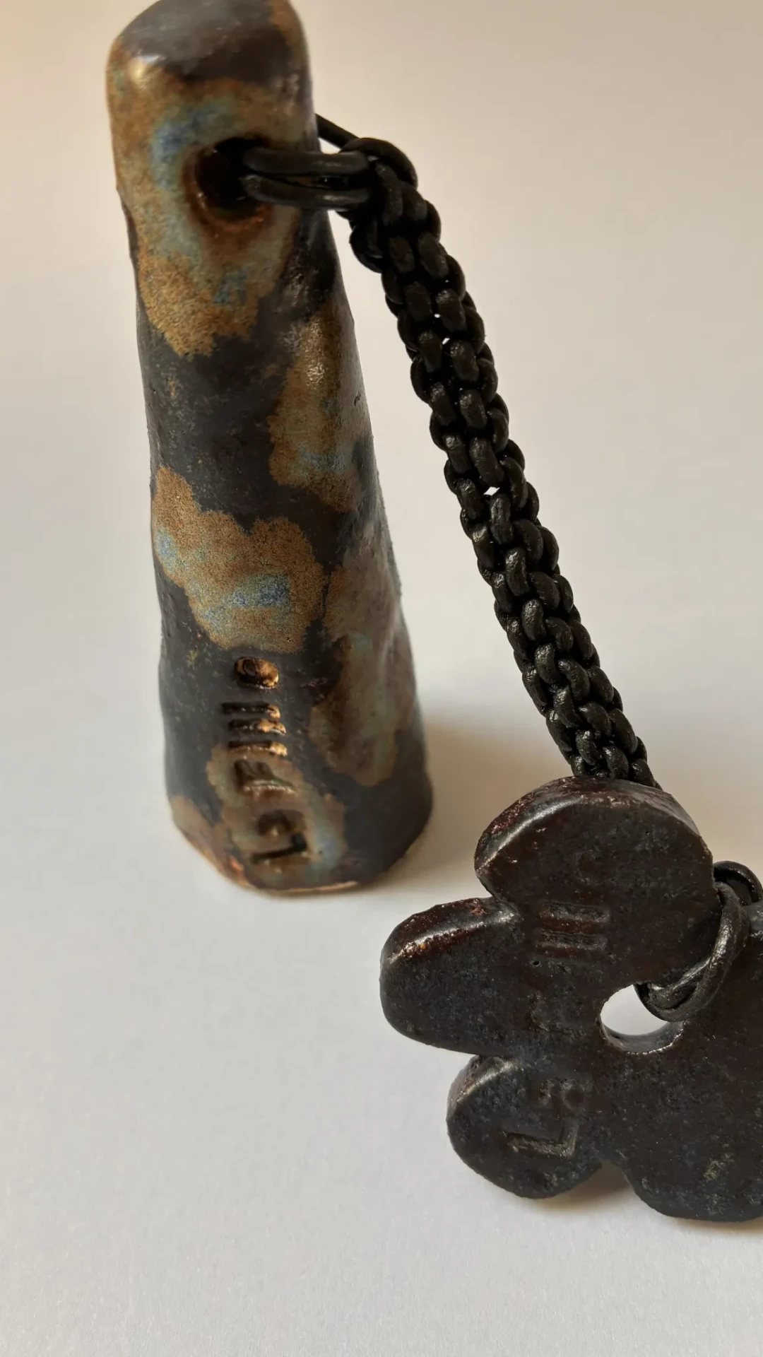 Détail des émaux Salamander et Pacifik, de la lanière en cuir tressé et des charms floraux en céramique de La Nuit.